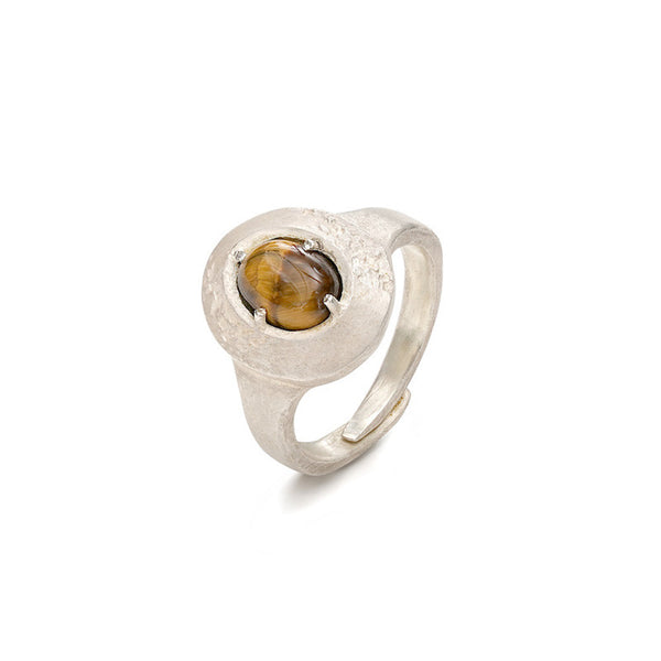 Silver ring with a tiger's eye stone on a white background