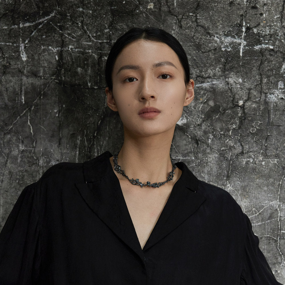 Woman wearing a black silver rose collar necklace