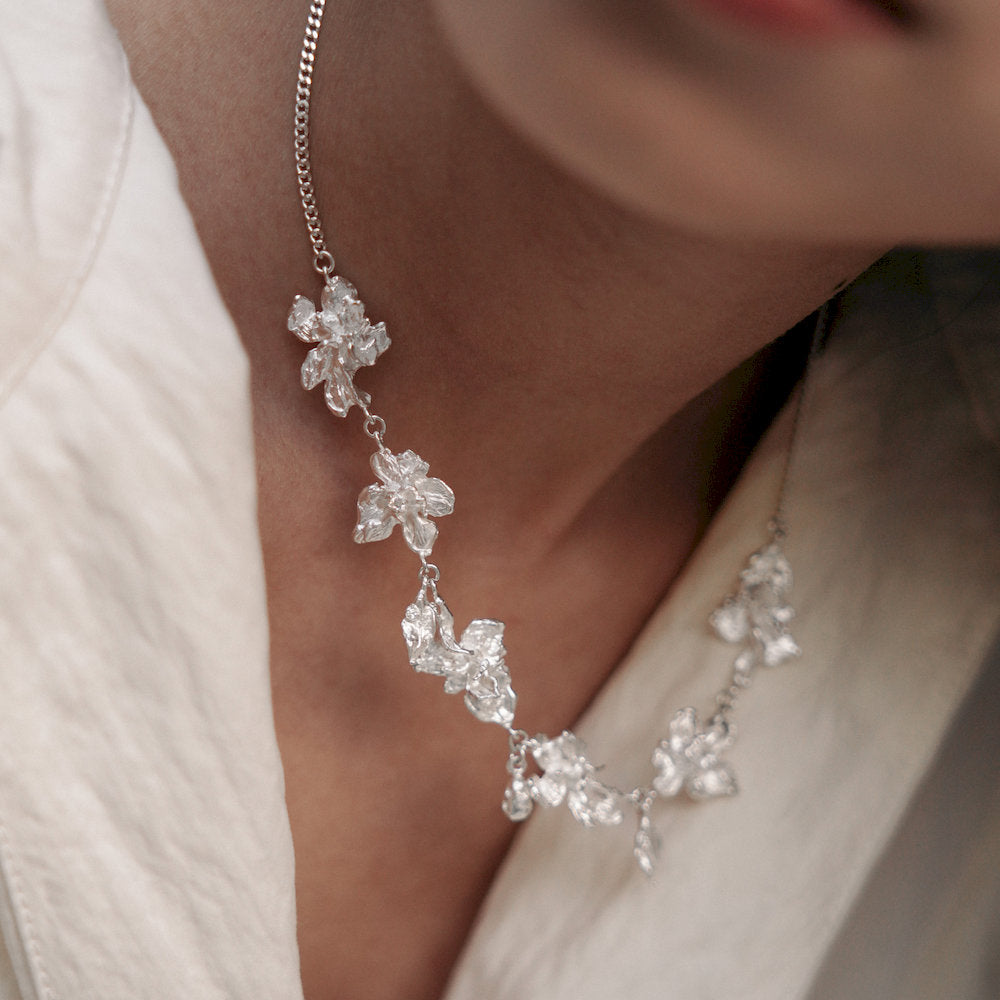 Silver floral statement necklace worn by a person